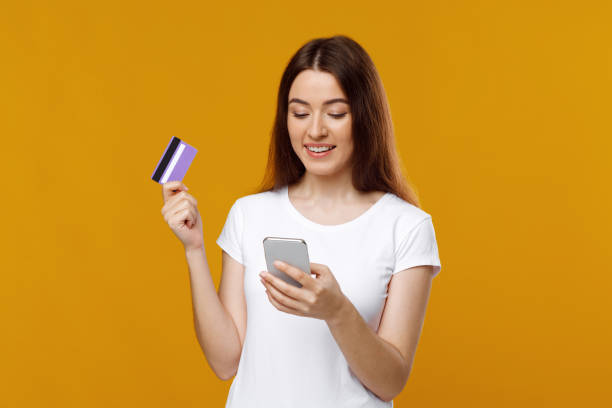 istock Happy young lady with smartphone and credit card 1342069014