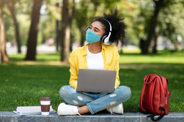 istock Black Student Girl In Face Mask Using Laptop Computer Outside 1342070456