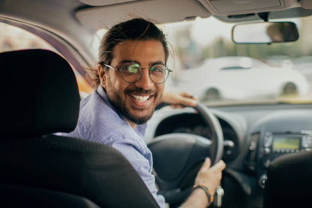 istock Cheerful middle-eastern taxi driver looking at back seat and smiling 1342070521