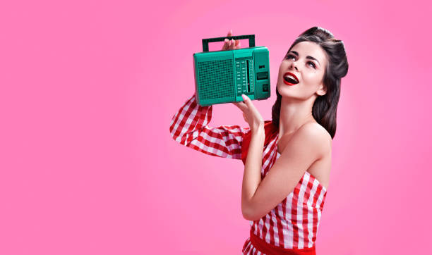 Beautiful brunette dressed in retro style listens to the radio stock photo