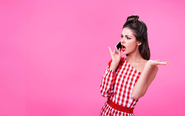 Beautiful young brunette dressed in retro style argues on the phone stock photo