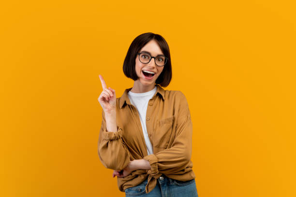 istock I have an idea. Emotional lady having great thought, finding inspiration or solution to problem, yellow background 1342073320