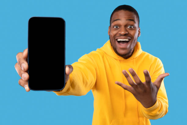 istock Excited African American Man Showing Phone Screen Over Blue Background 1342073382