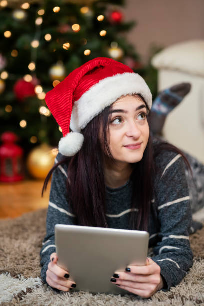 istock Young woman using digital tablet at Christmas time 1342073424