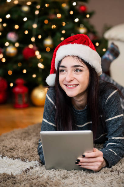 istock Young woman using digital tablet at Christmas time 1342073431