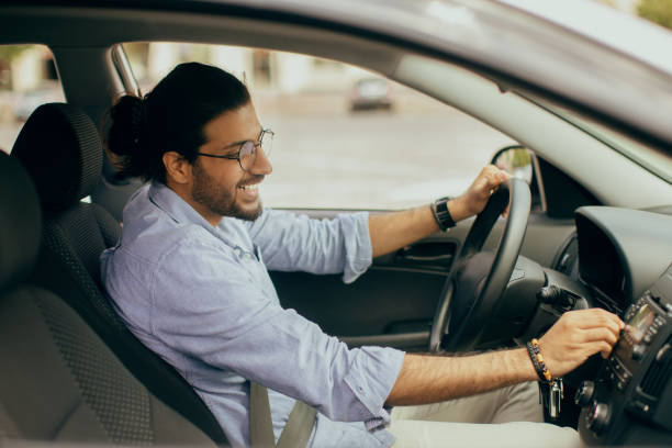 istock Cheerful arab guy with fasten seat belt turning on music 1342074918