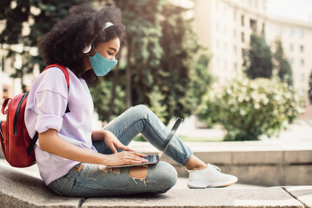 istock Black Student Girl Learning Using Laptop Wearing Face Mask Outside 1342076777