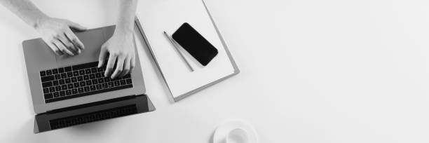 istock Top view image of young employee typing on laptop. Business projects. Work communication. Black and white effect 1342077020