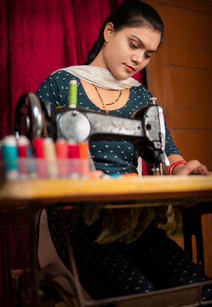 istock Indian woman sewing clothes by machine at home. 1342079451