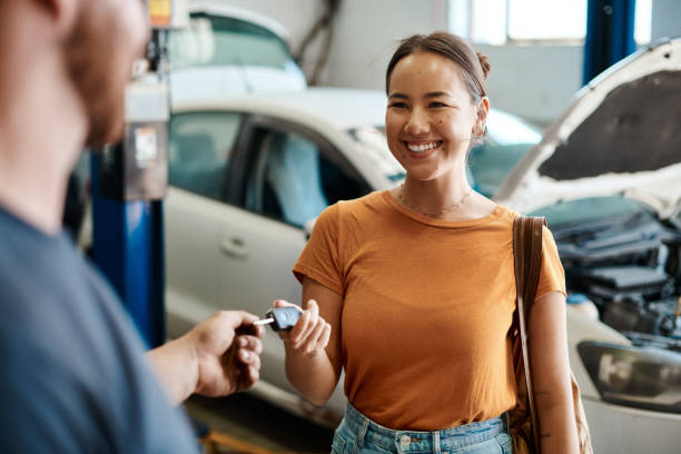 ujęcie kobiety otrzymującej kluczyki do samochodu - auto repair shop garage car mechanic zdjęcia i obrazy z banku zdjęć