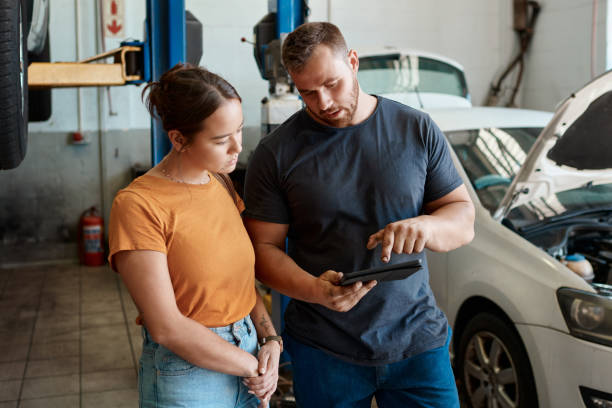 Shot of a woman talking to a mechanic in an auto repair shop We picked up the problem almost instantly auto repair shop mechanic digital tablet customer stock pictures, royalty-free photos & images