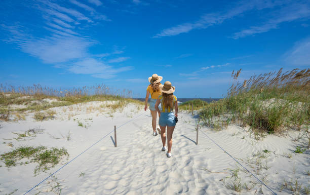 istock People walking on white sand to the ocean. 1342083350