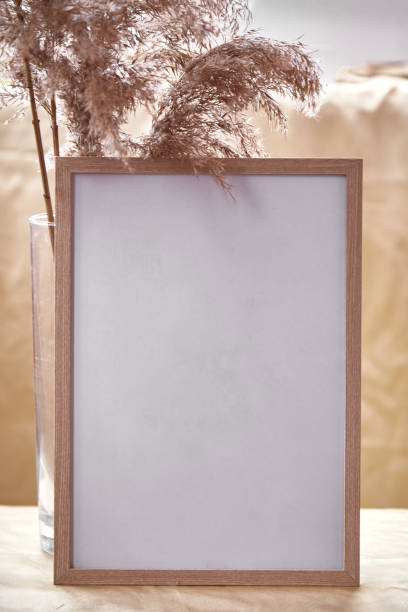 istock Minimalistic mock - up frame with dry flowers decorations. Cozy home atmosphere mockup. Natural beige background 1342084294
