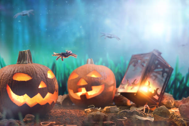 Two halloween pumpkin and lit lantern at night in forest