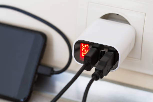 istock The charger is plugged in. Smartphone is charging from socket charger for three USB ports output with voltage indicator. Closeup, selective focus 1342088761