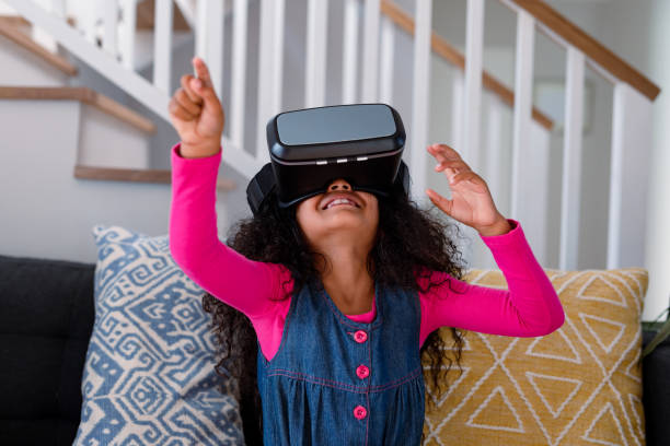 istock Happy african american girl sitting on sofa, using vr headset and having fun 1342089272