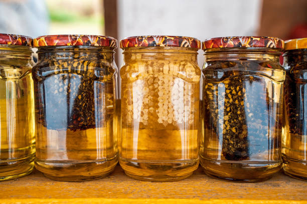 istock Honey with honeycombs in jars on the market 1342089356