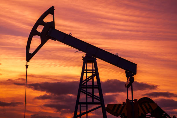 нефтегазовая промышленность. нефтяная насосная нефтяная вышка энергетическая промышленная машина для нефти на фоне заката, увеличение до� - oil стоковые фото и изображения