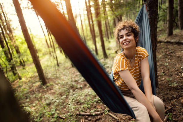 istock Female hiker sitting in a hammock in the pine forest 1342093119