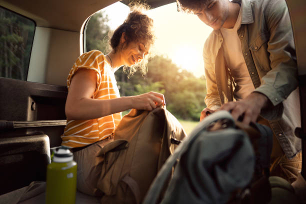 istock Cheerful young couple preparing their backpacks a for hike in the forest 1342093142