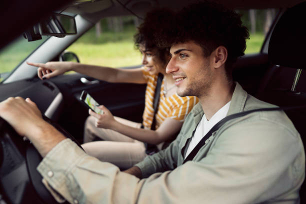 istock Young couple navigating with smart phone on a road trip 1342093163