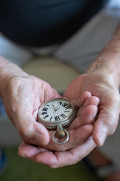 istock Old men holding very old watch in his hand 1342093308