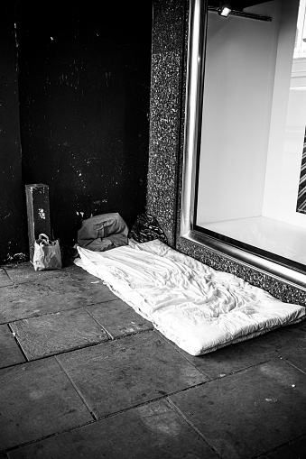 Homeless persons' empty bed under a shop window in the centre of the affluent Cotswold town of Cheltenham in Gloucestershire