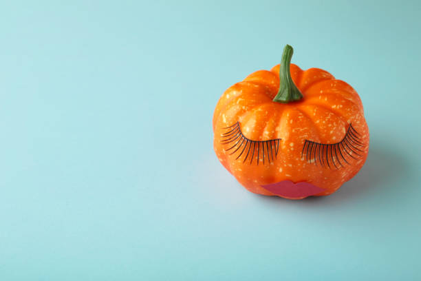 istock Halloween pumpkin with make up on blue. Minimal Holiday season concept background. 1342094663