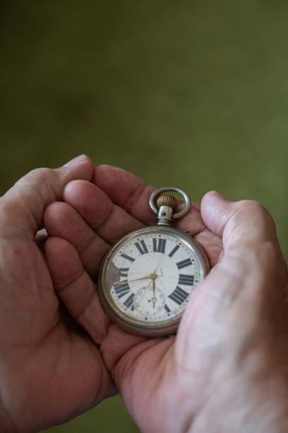 istock Old men holding very old watch in his hand 1342095138