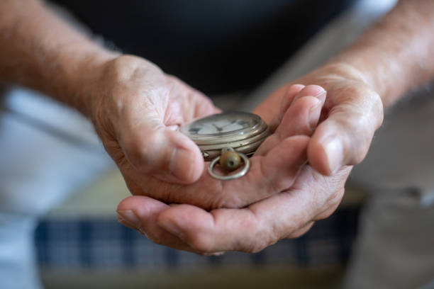 Old men holding very old watch in his hand