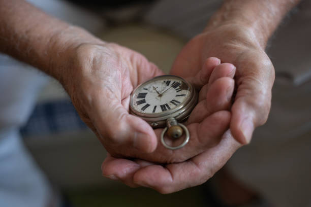 istock Old men holding very old watch in his hand 1342095243