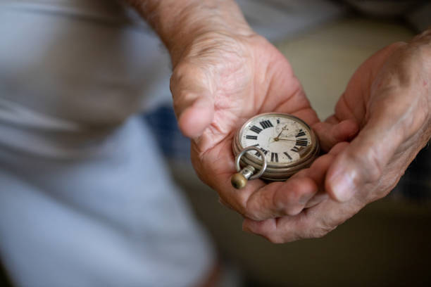istock Old men holding very old watch in his hand 1342096726