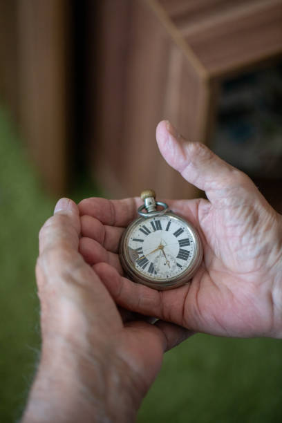 istock Old men holding very old watch in his hand 1342096767