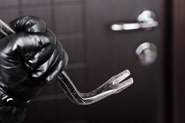 Burglar hand holding crowbar break opening door Crime scene - thief or burglar hand in gloves holding metal crowbar break opening home door lock burglary crowbar stock pictures, royalty-free photos & images