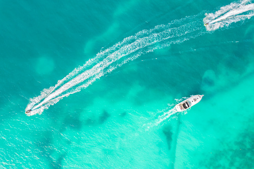 Amazing top view of yacht. Aerial view of luxury floating small ship in blue Caribbean sea. Yacht at the sea in Cancun, Mexico