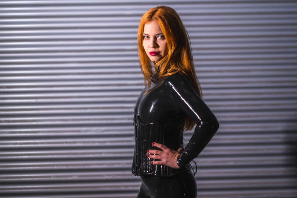 istock Redhead girl in latex, a black top and tight pants 1342101607
