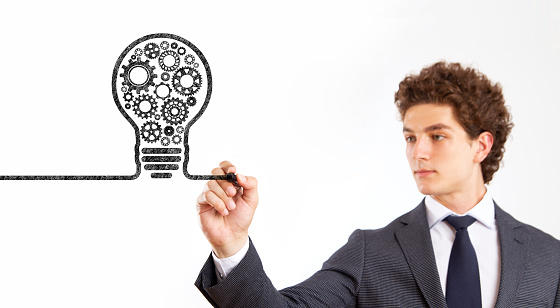 Businessman drawing light bulb made of gears for new business and strategies