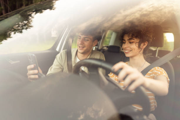 istock Cheerful couple navigating with smart phone on a road trip 1342102751