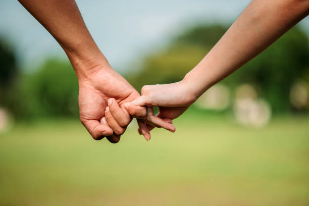 istock Asian couple holding finger in public park 1342103376