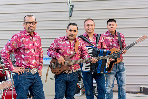 Hispanic music group posing before a concert