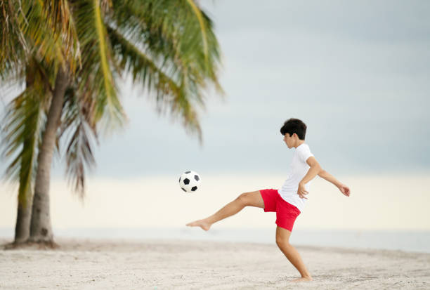 istock Teen practicing ball control with a soccer at a beach in Miami 1342105822