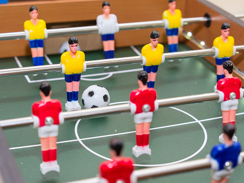 table football detail of colorful players (figurines), one of them and ball in focus the others out of focus