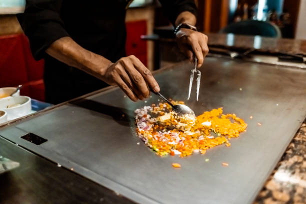 chef cocinando en el restaurante japonés teppanyaki - teppan yaki fotografías e imágenes de stock