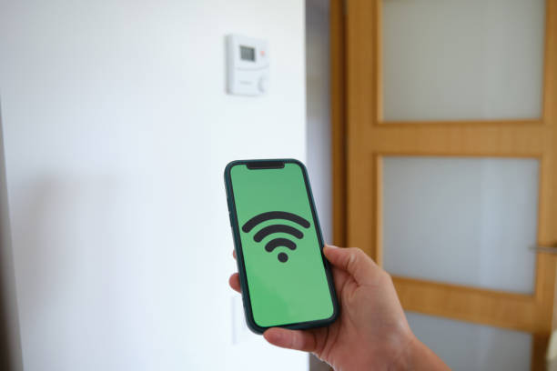 istock Woman using smart home control app on her smartphone to manage digital devices in modern apartment using wifi internet. 1342111914