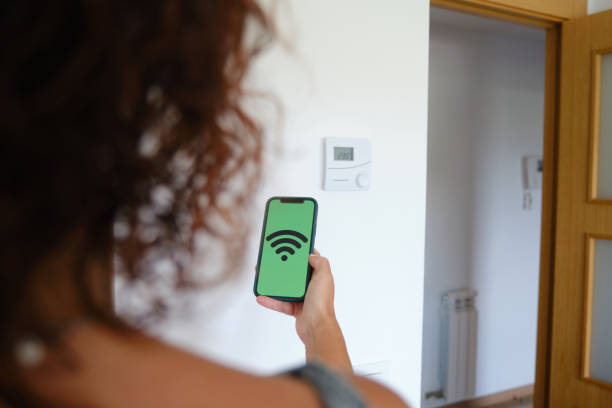 istock Woman using an application on her smartphone to control temperature regulation and climate at smart home using wifi internet. 1342111928