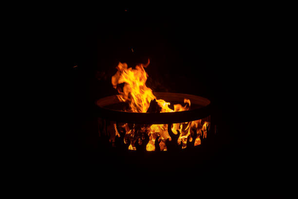 Side angle view of fire in an outdoor fire pit at night