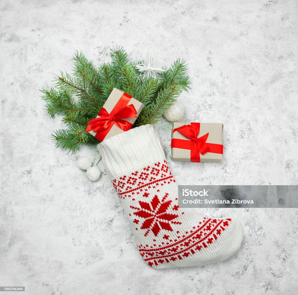 Christmas stocking white with fir branches on a light background. Christmas Stocking Stock Photo