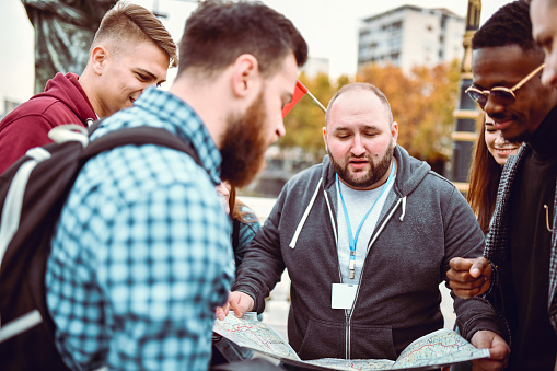 Tour Guide Explaining Bald Tour Guide Explaining Locations On Map To Tour Group Stock Photo ...