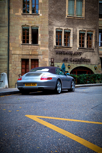 Geneva, Switzerland - August 7, 2011: Porsche 911-997 Carrera S Cabrio in Geneva Streets, parked in the entrance of Restaurant Au Carnivore. The Porsche 997 is the most commercially successful 911 of ever, having sold 100,000 cars between 2005 and 2007.