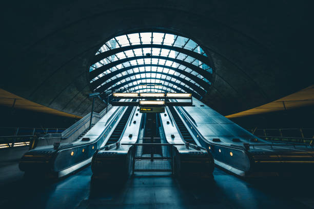 pendler auf rolltreppe an der u-bahnstation canary wharf - london england vanishing point underground diminishing perspective stock-fotos und bilder